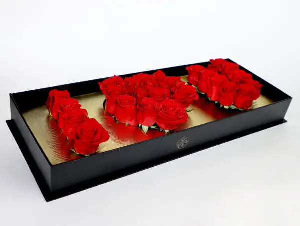 Caja de rosas rojas en diseño 'I LOVE YOU' con base dorada y caja negra de lujo