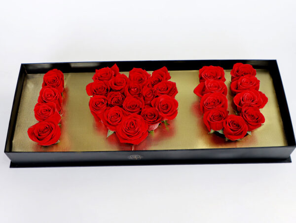 Caja de rosas rojas en diseño 'I LOVE YOU' con base dorada y caja negra de lujo