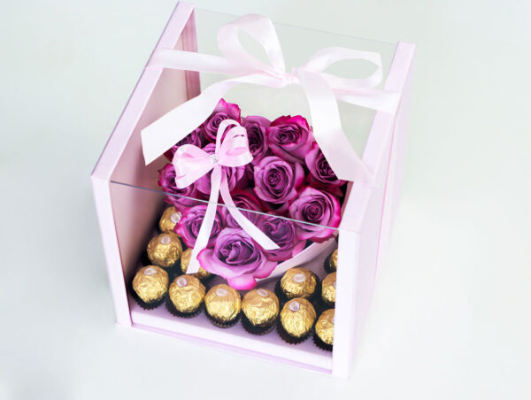 Arreglo floral en forma de corazón con rosas rosadas frescas y una caja de bombones Ferrero Rocher.