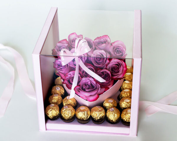 Arreglo floral en forma de corazón con rosas rosadas frescas y una caja de bombones Ferrero Rocher.